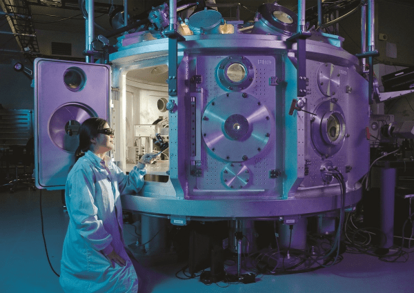 scientist looking inside of a machine